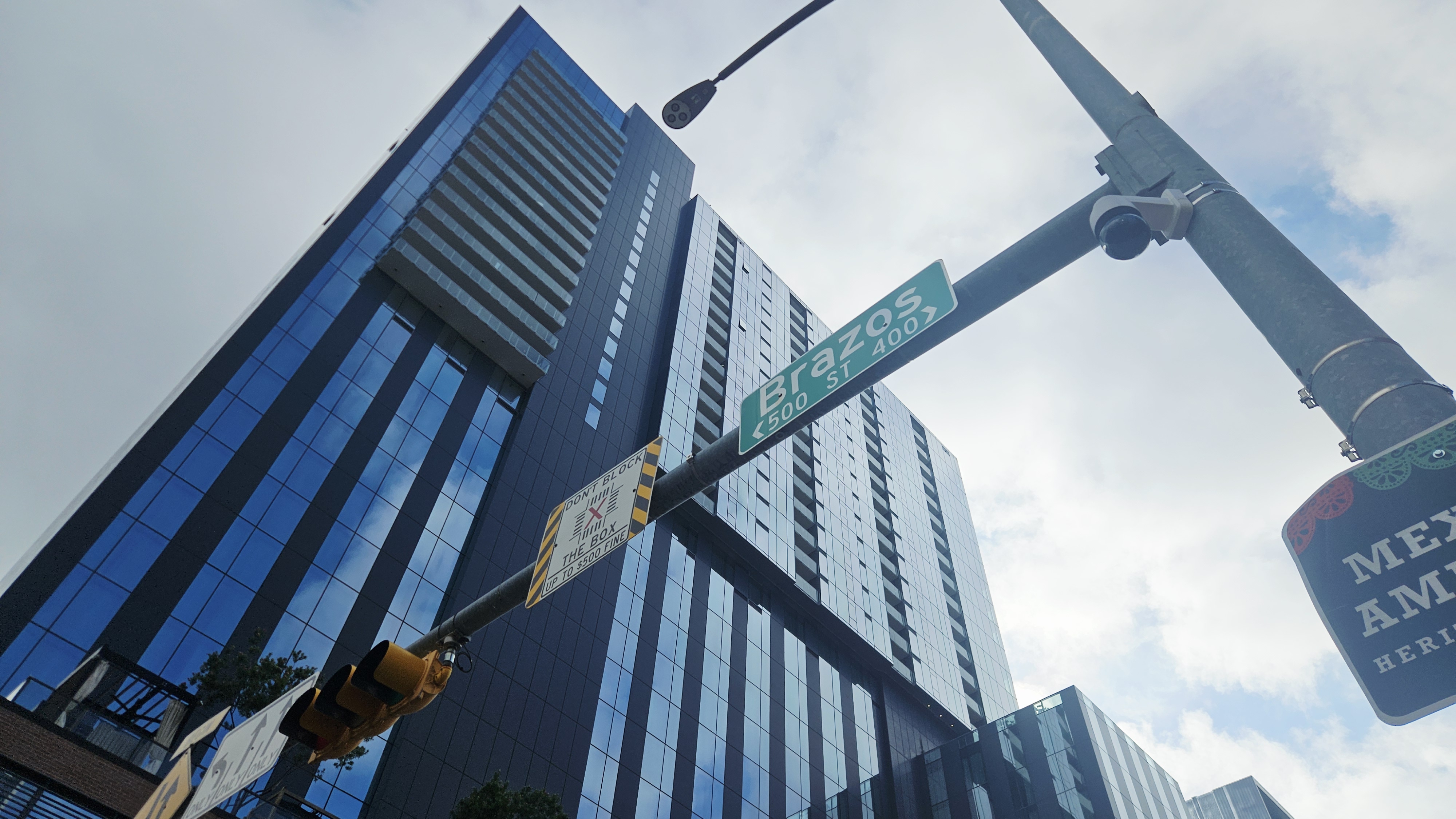 Urban skyline looking up at modern glass towers against a cloudy sky